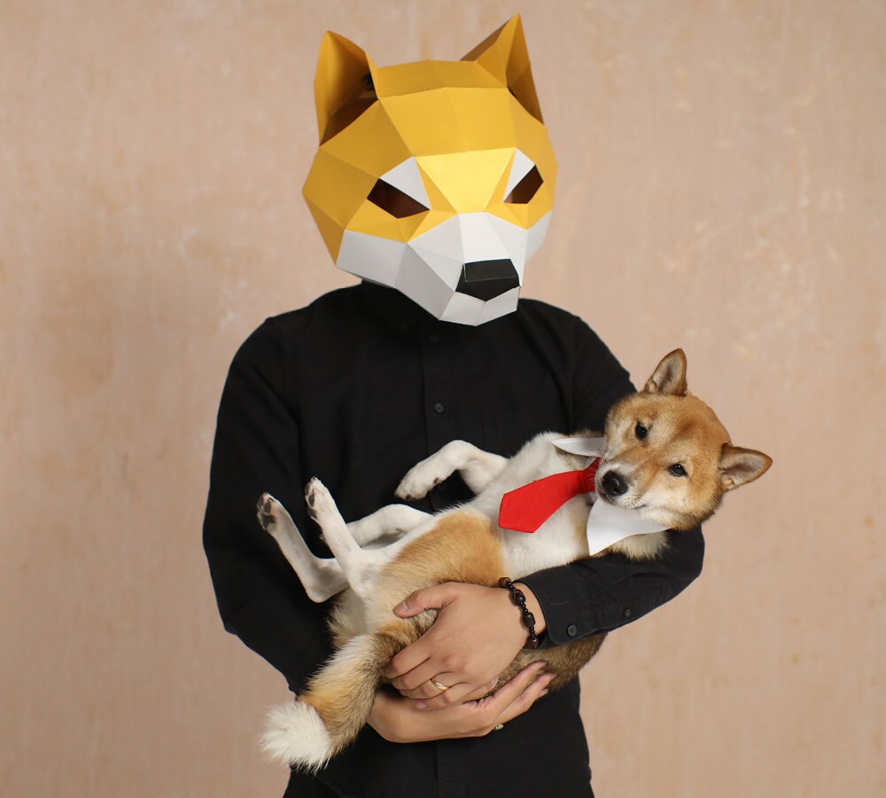 A man dressed as his dog holds his dog, who is dressed as the man.