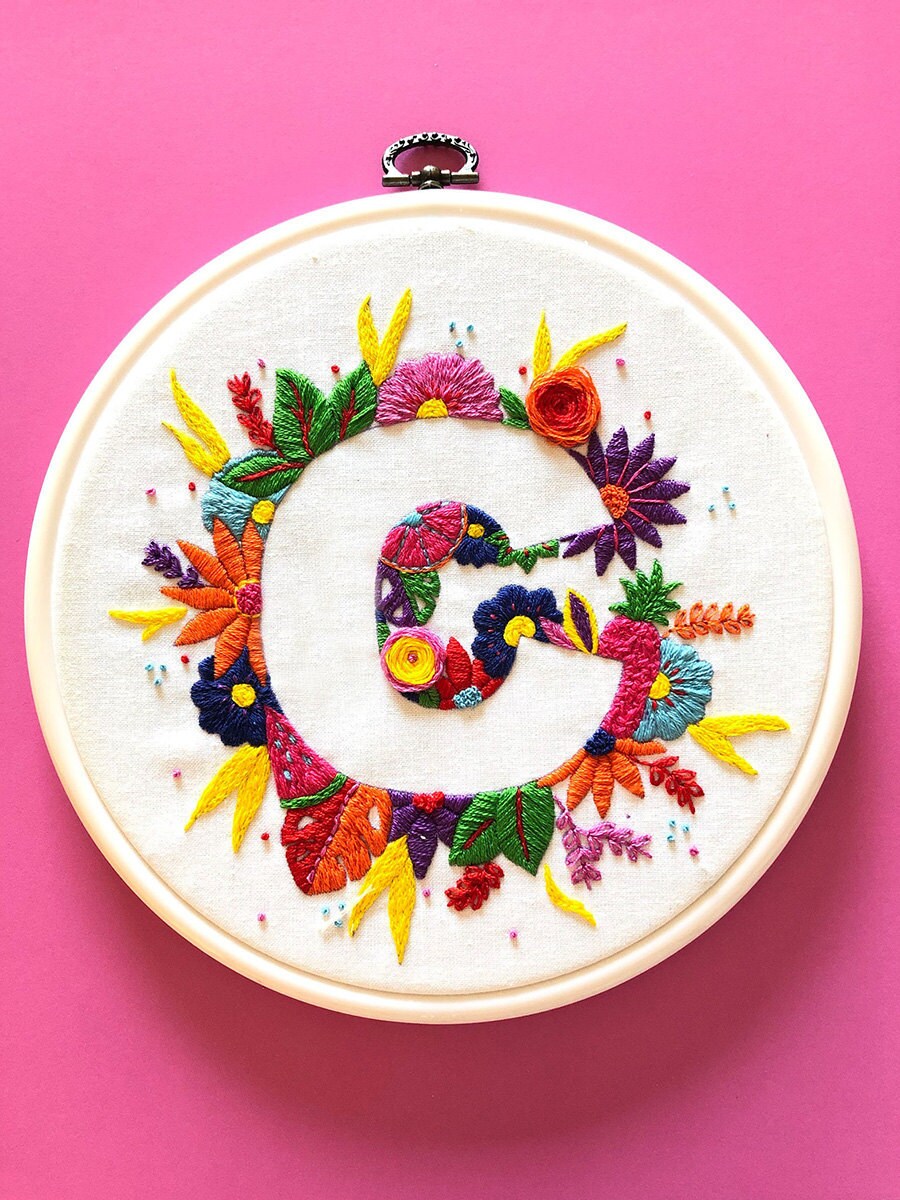 A monogram embroidery hoop with the letter "C" surrounded by stitched flowers.