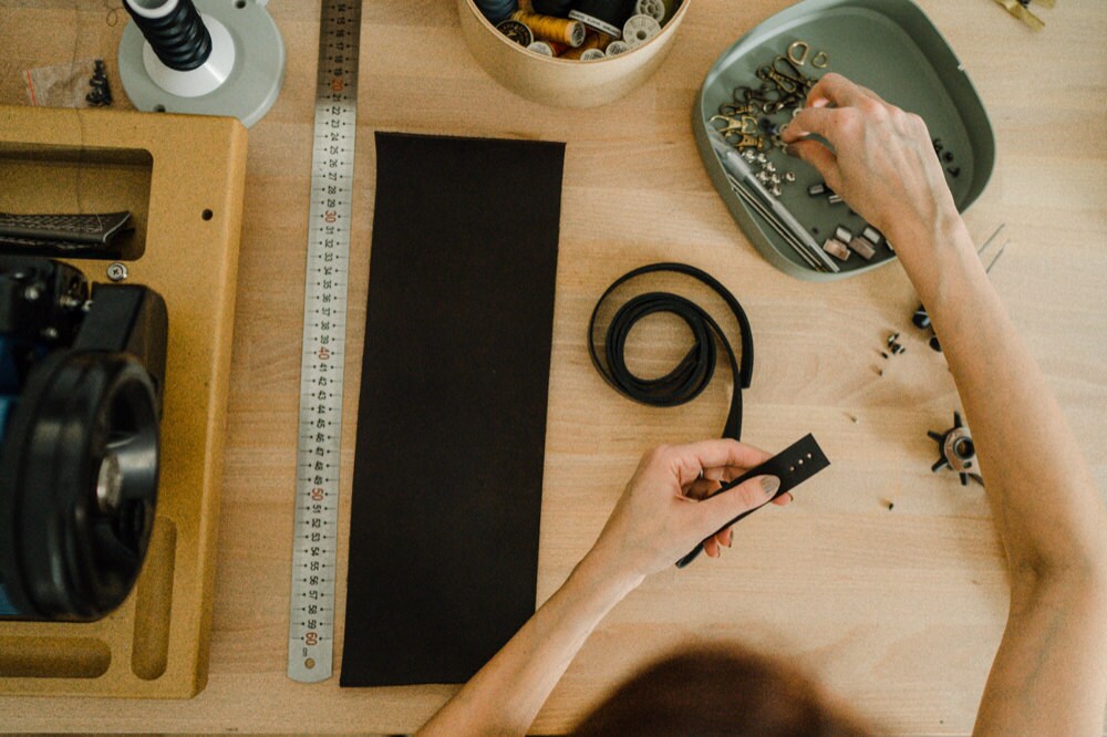 Eda adding fasteners to a bag strap