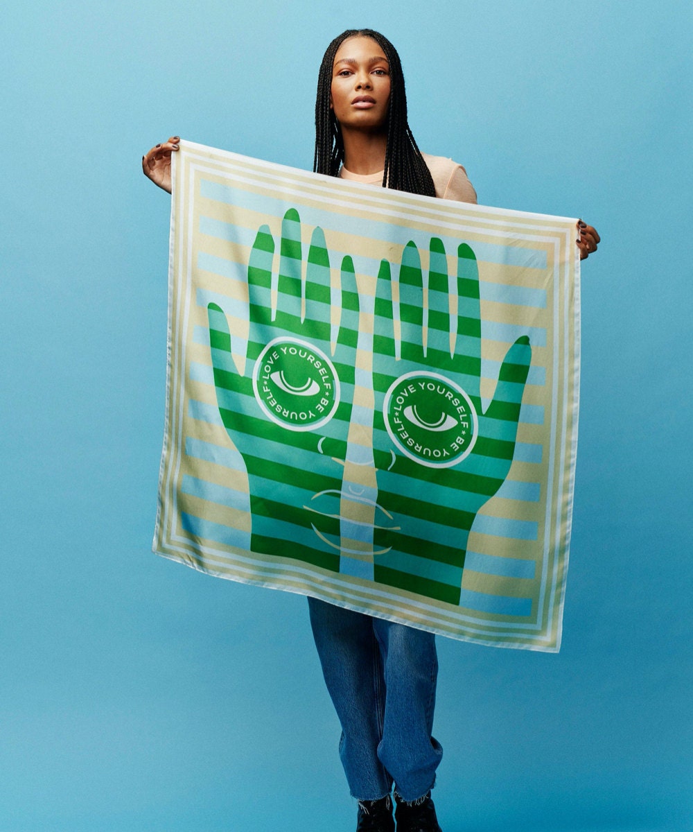 A "Be Yourself, Love Yourself" scarf from the Honey Dijon Creator Collab, designed by All Very Goods