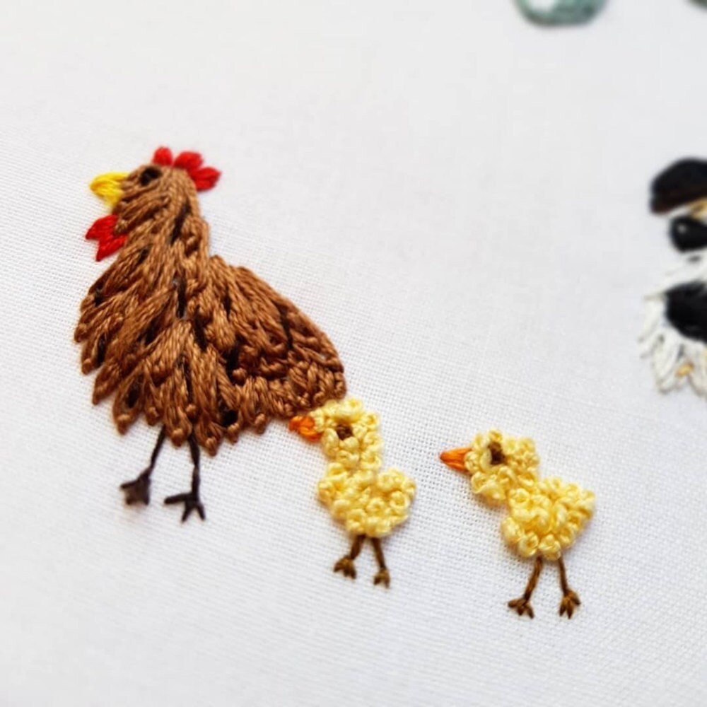 Close up detail on an embroidered chicken and baby chicks from one of Natalie's "new home" hoops.