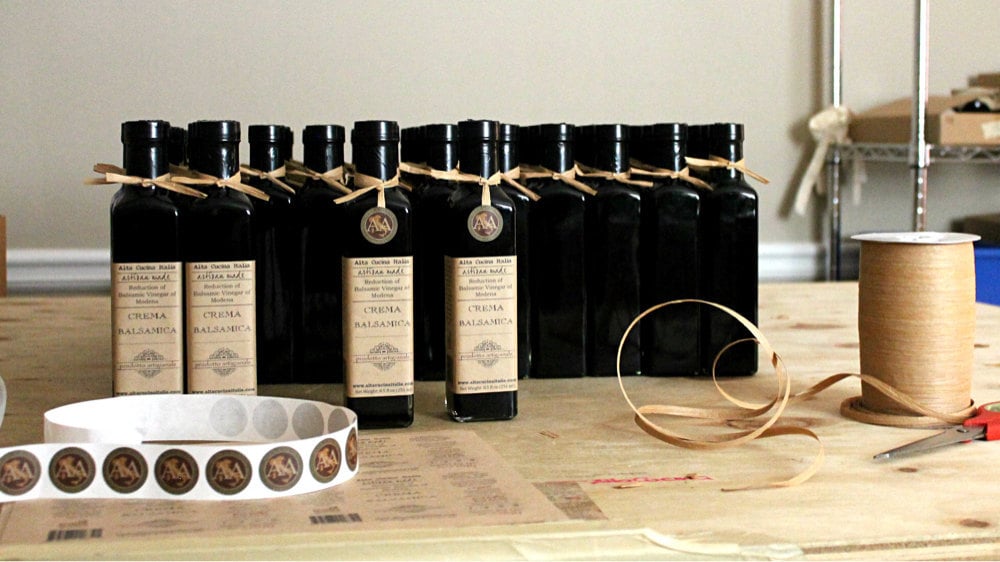 Bottles of balsamic getting labeled and ribboned
