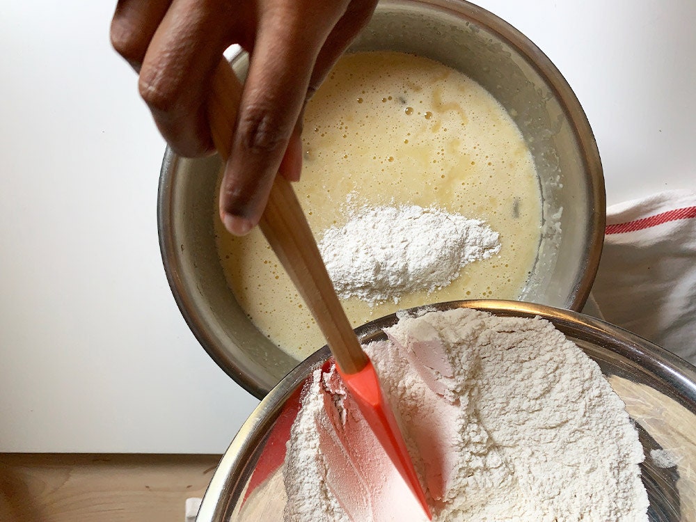 Aravis adding dry ingredients to the wet ingredients.