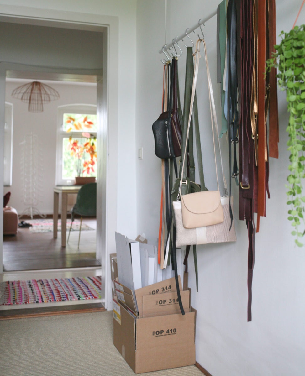 Colorful leather bag straps hanging on a rack