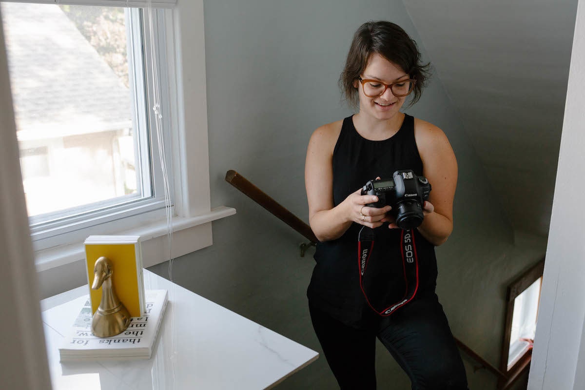 Brenda photographing brass duck bookends for sale in her home