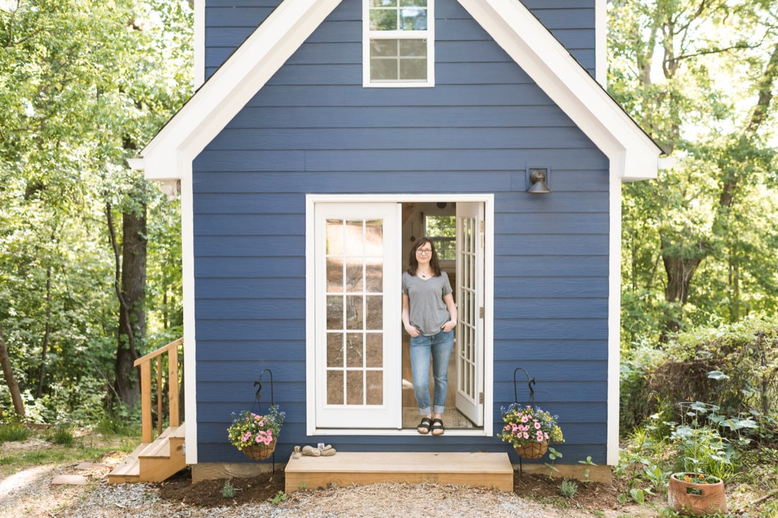 Portrait of Liz outside her cozy blue house in Asheville, NC