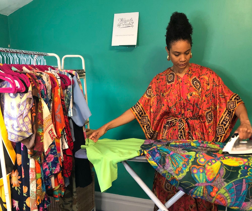 Halima ironing a vintage dress.
