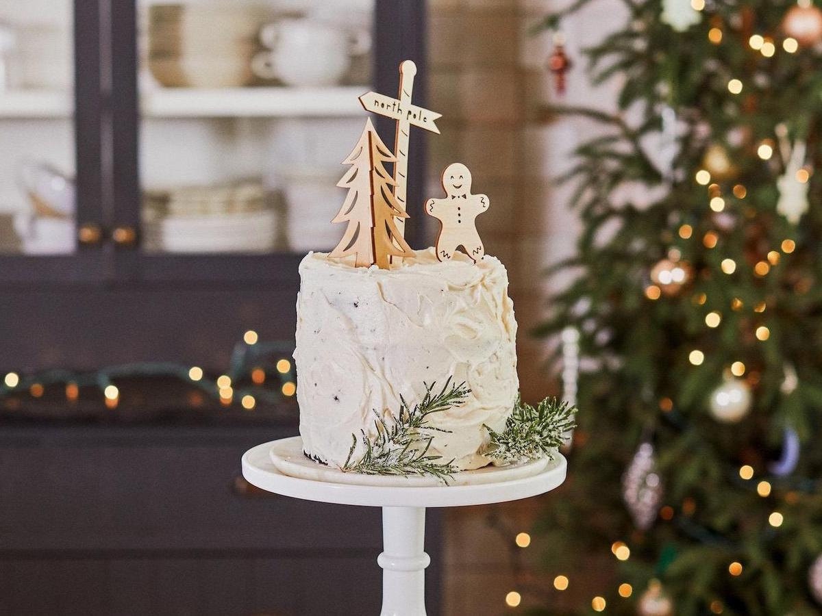 Holiday cake toppers by Light + Paper (from the Half Baked Harvest x Etsy collection) styled on a frosted cake.