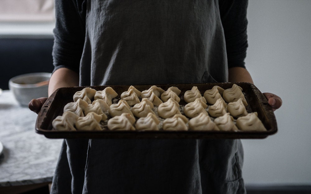 Cynthia carrying a tray of dumplings