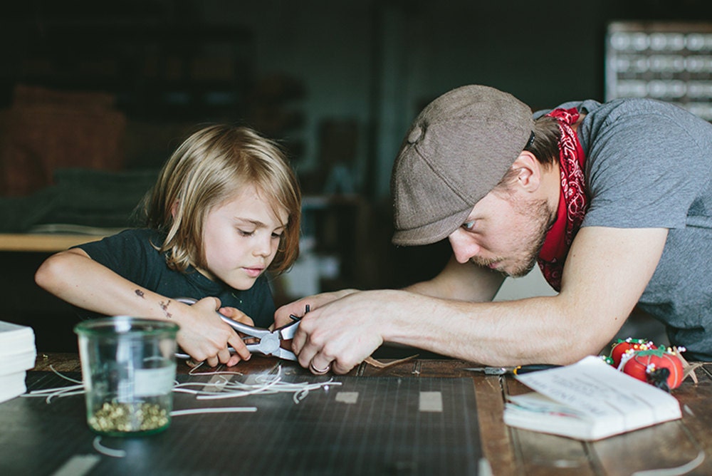 Walter and son working do some leather-working together in the studio.