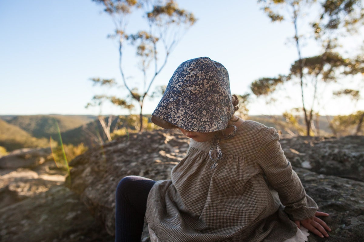 Child at play wearing an écolier kids smock and bonnet