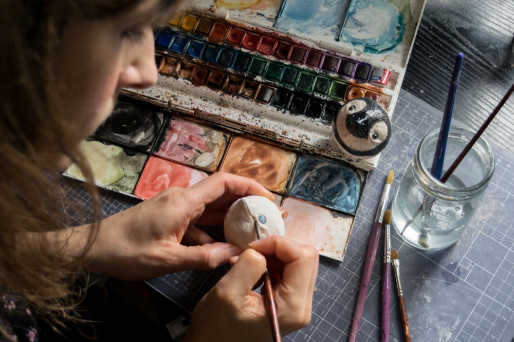 Kayleigh painting facial features onto her animal ornaments