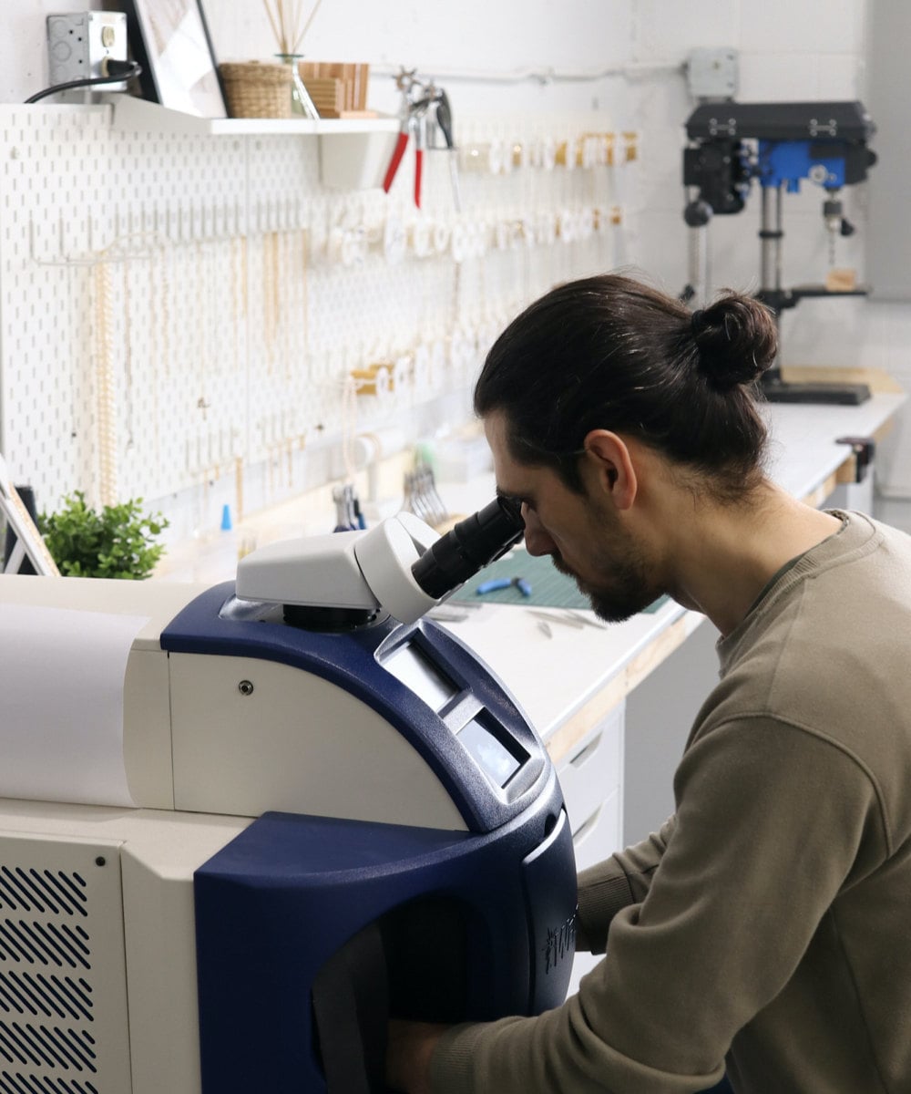 Abe uses the laser engraving machine to customize a piece.