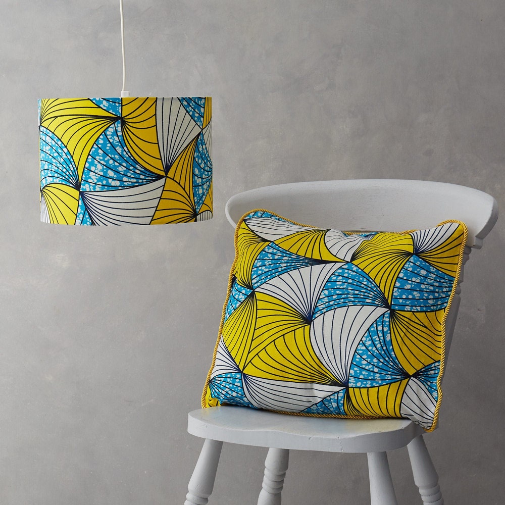 A matching blue and yellow African wax print lampshade and pillow cover from Bespoke Binny,