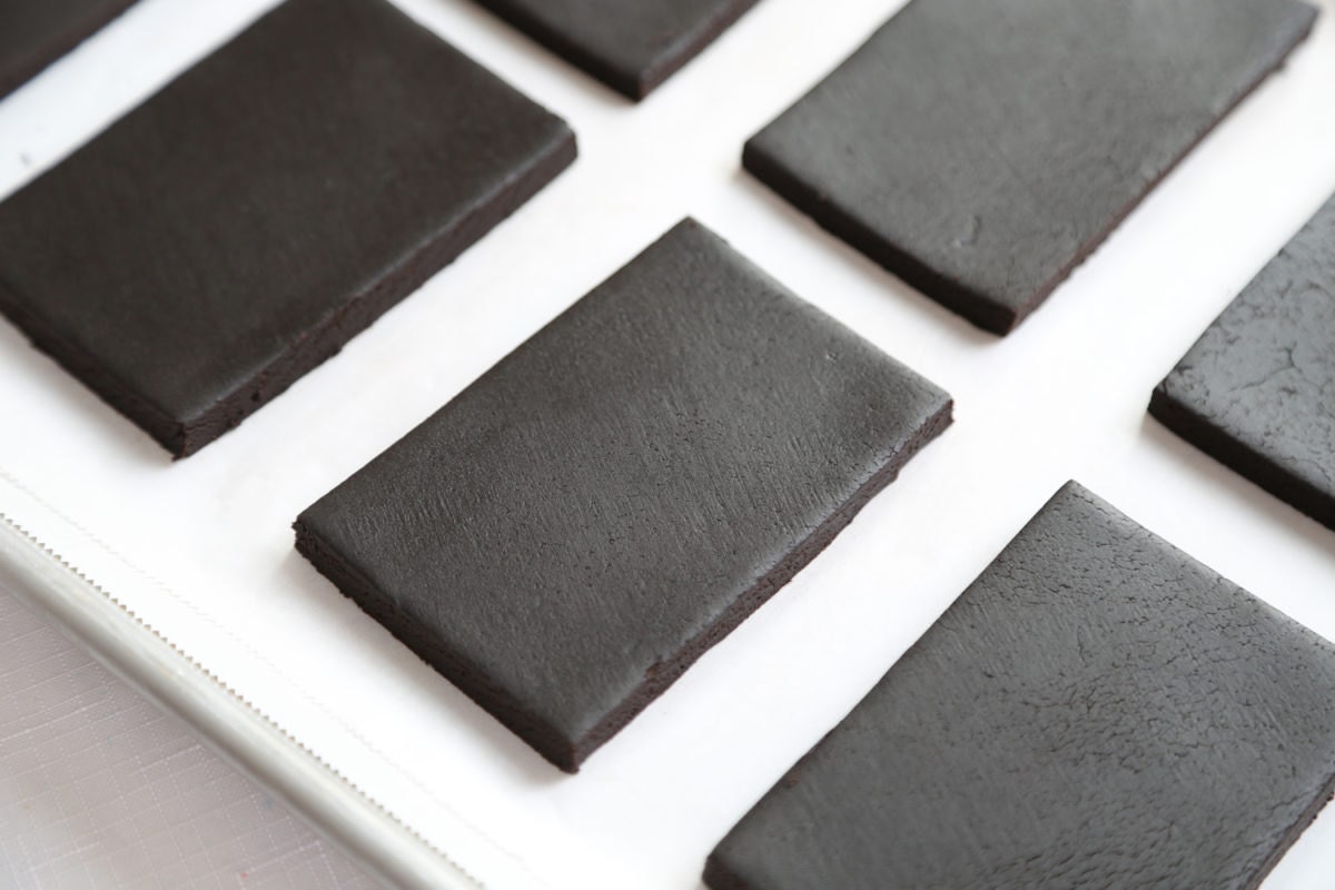 Parchment paper-lined baking sheets featuring rows of rectangular cookies.