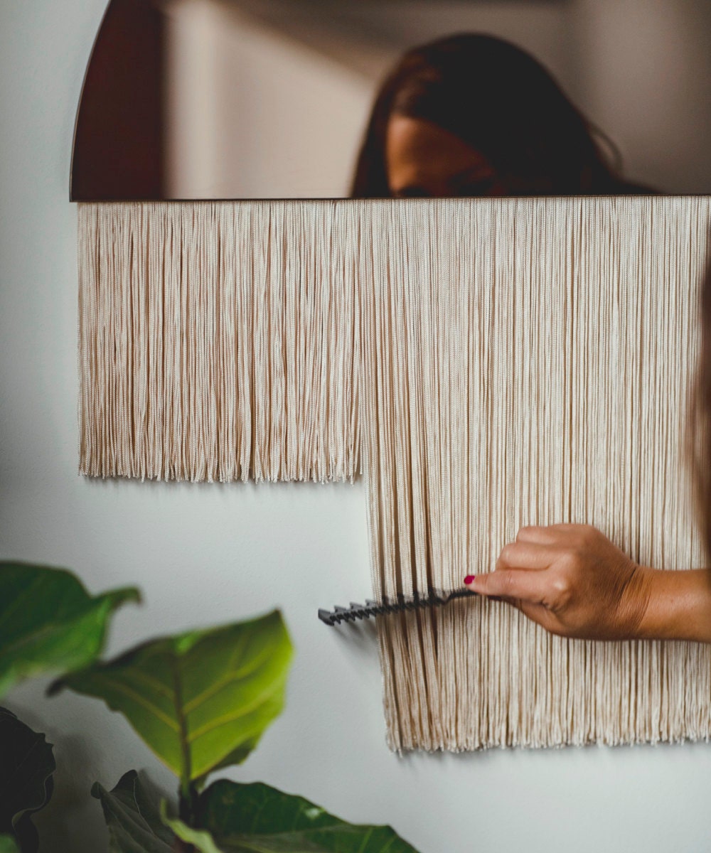 Candice combs the fiber threads on a half-moon fringe piece.