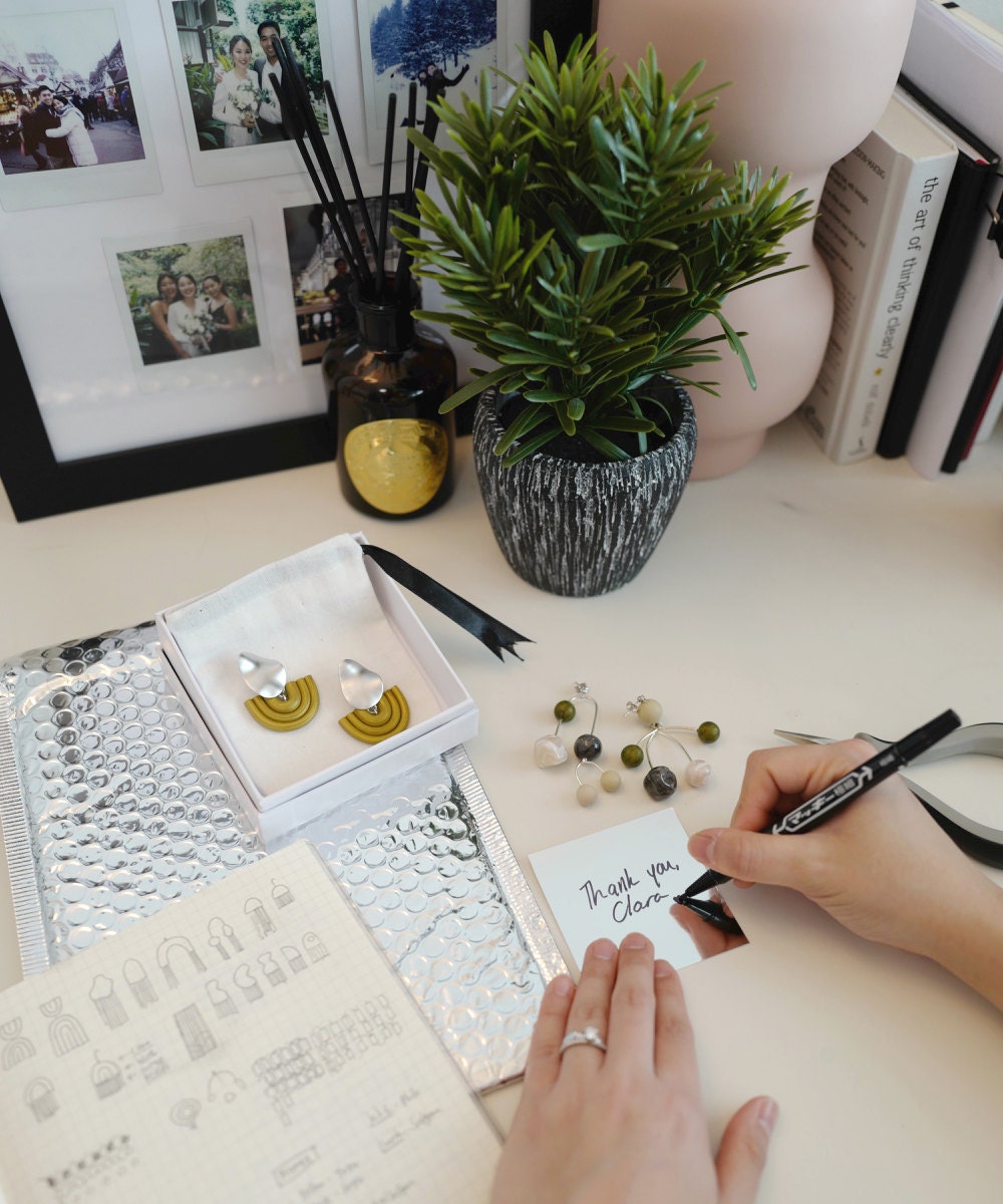 Jessica packing up an order and writing a thank you note to a customer.