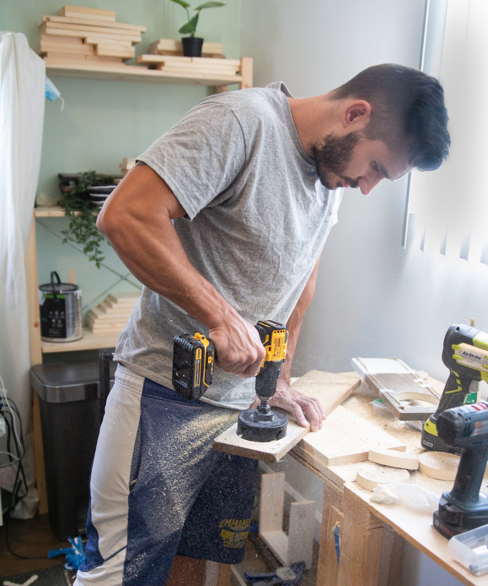 Mike cuts a hole for a planter into a piece of wood.