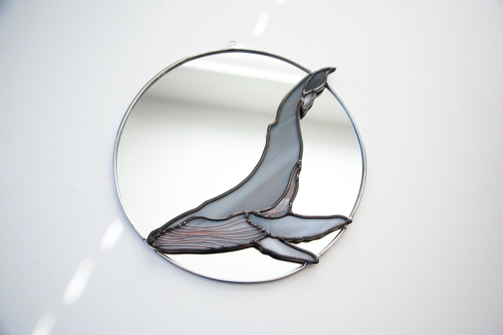 A circle mirror decorated with a stained glass humpback whale from Szklo Glass