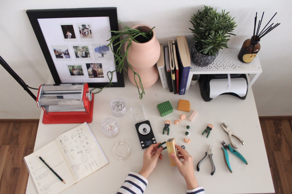 Jessica at her desk, cutting polymer clay to begin shaping new pieces.