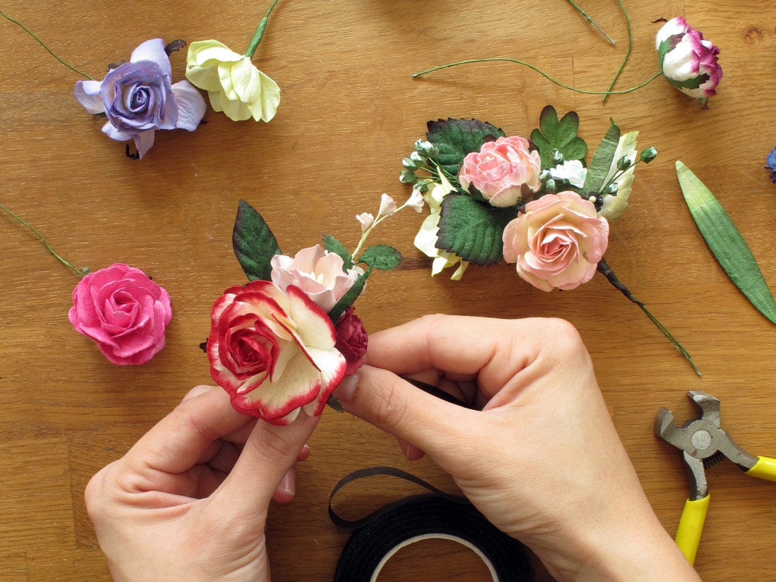 Orawee assembles colorful paper flowers into a harmonious batch for crafting