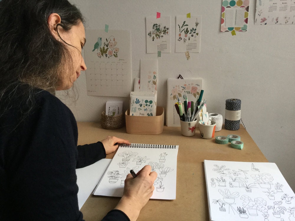 Yolande Six drawing in her sketchbook at her desk Yolande Six drawing in her sketchbook at her desk
