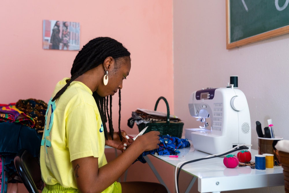 Rachelle mending a vintage garment at her sewing machine.