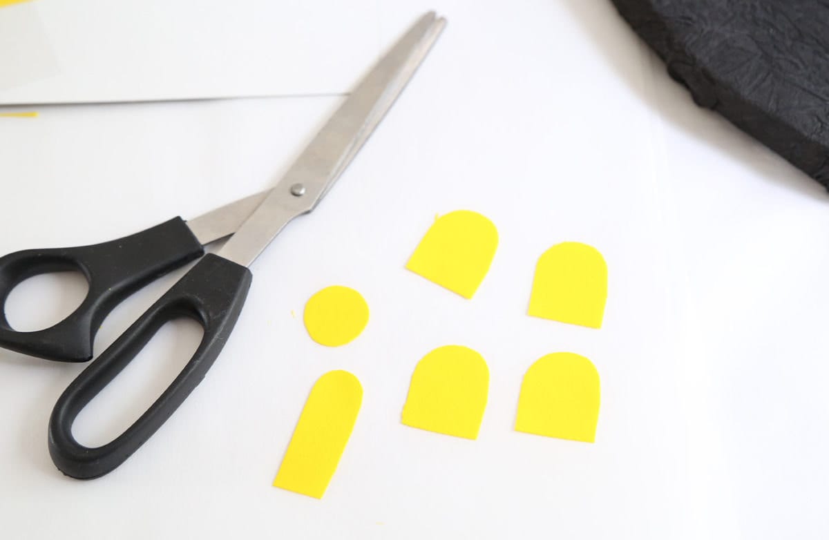 A pile of yellow doors and windows cut from a sheet of icing.