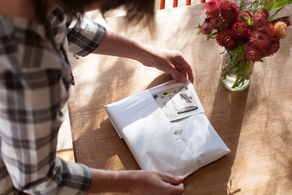 Madeline packaging an order in her sunny studio