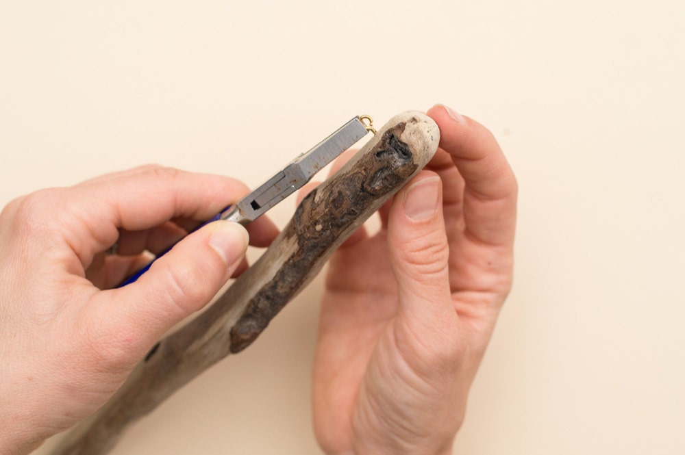 Screwing a small eye hook into the end of the piece of driftwood