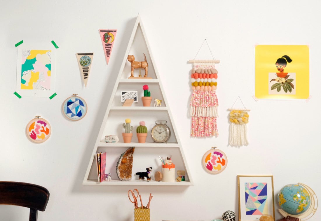 A shelf styled with colorful school supplies and framed by lots of vibrant wall art.