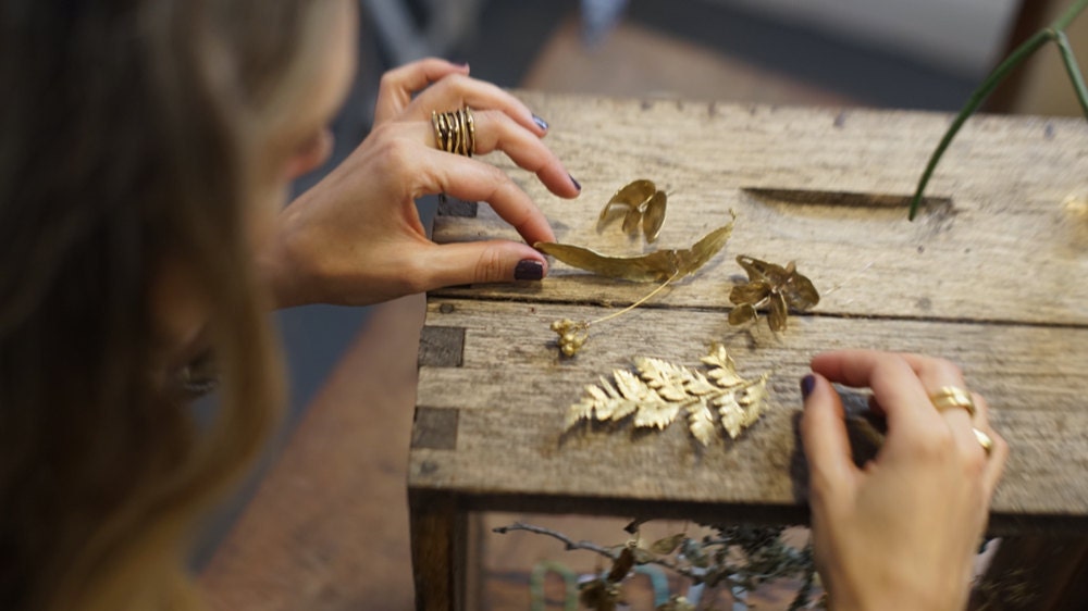Maria assembles delicate botanical jewelry in her studio