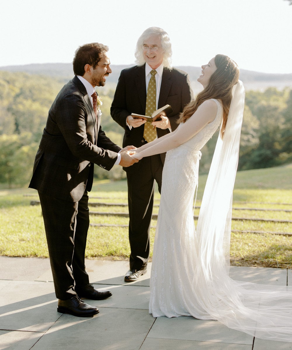 Megan and Imran exchanging vows as Megan's father officiates.