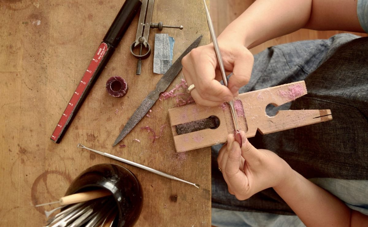 Shuang working on a piece of jewelry at her workbench