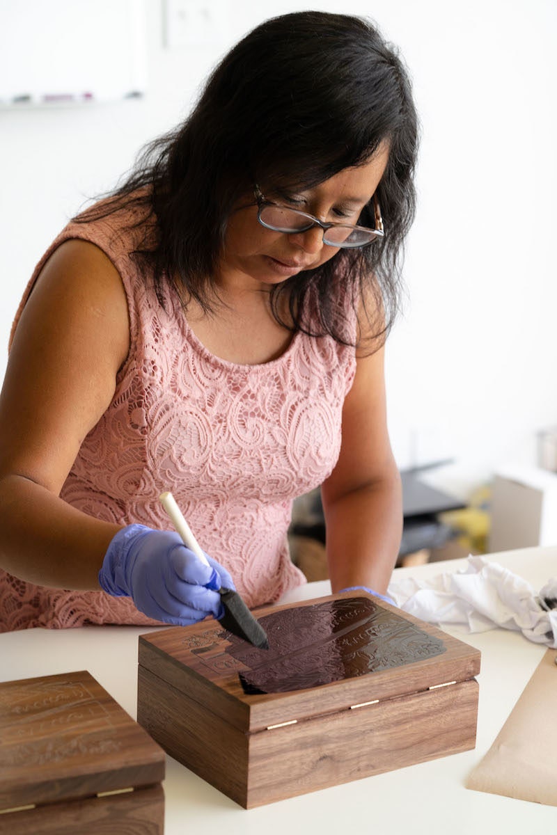 A member of the Hereafter team works on a wooden keepsake box