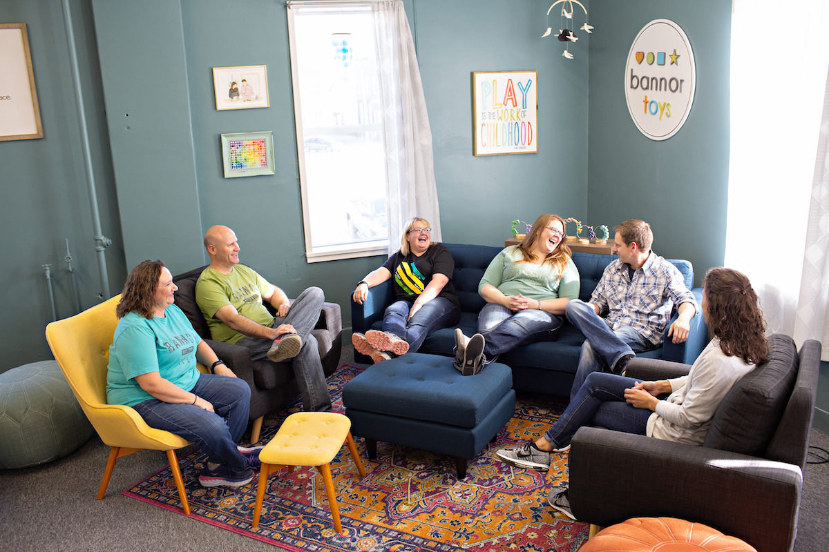 Stacey and Jesse Bannor laughing with members of the Bannor Toys team in their studio