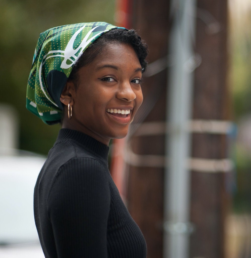 A woman models the Little George bandana design as a headwrap.