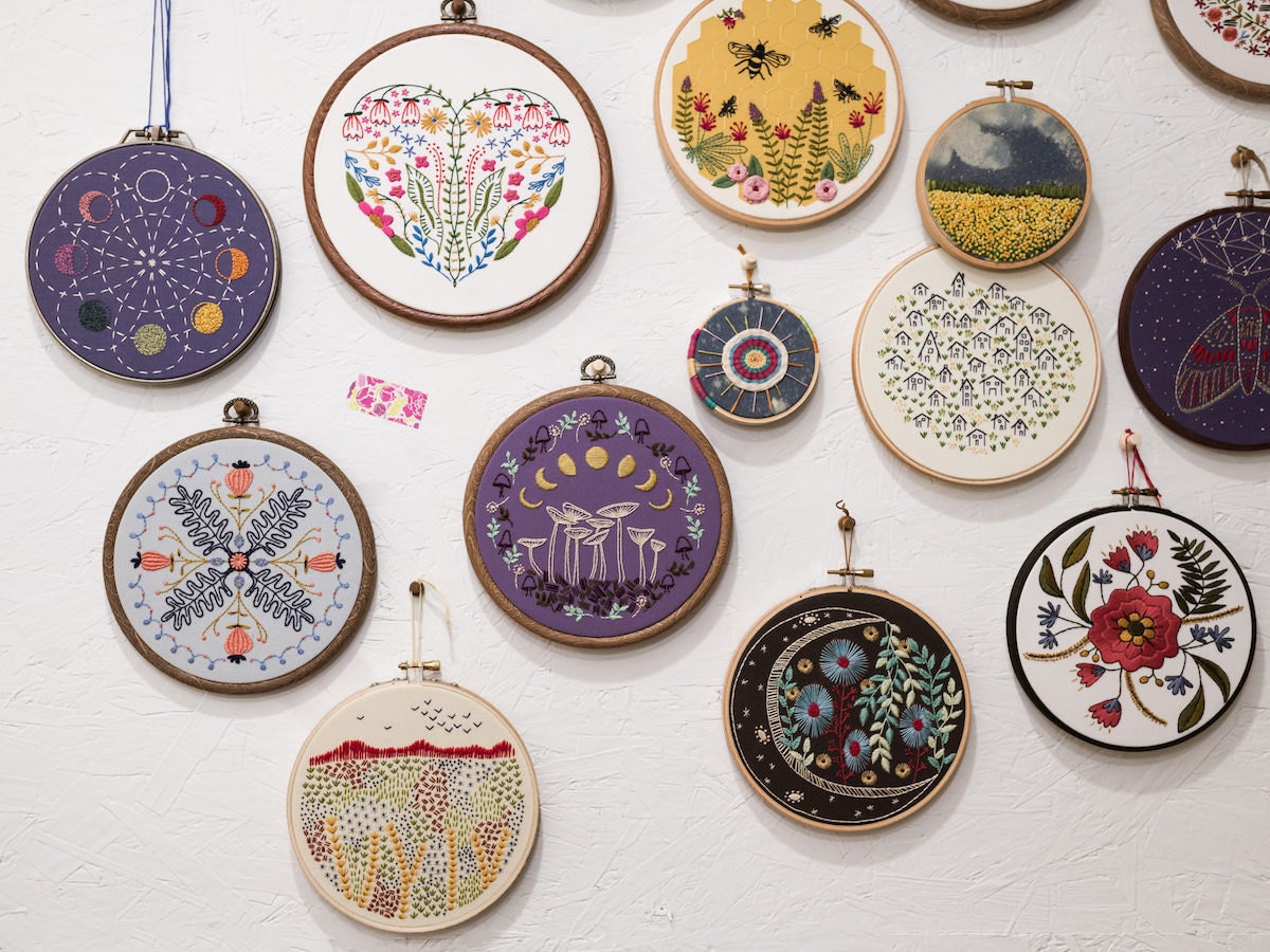 A wall adorned with completed Cozy Blue embroidery hoops