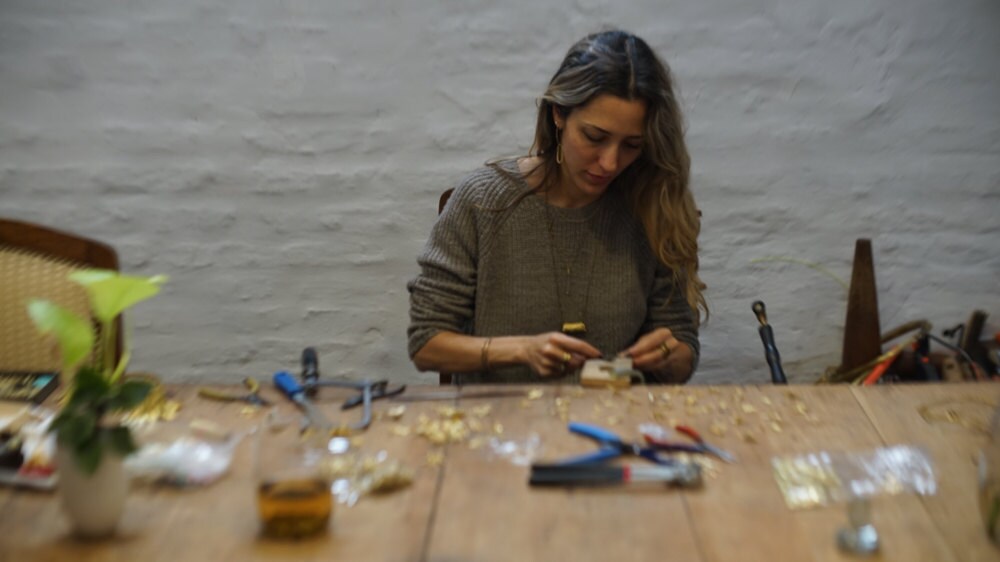 Maria creating jewelry at her workbench