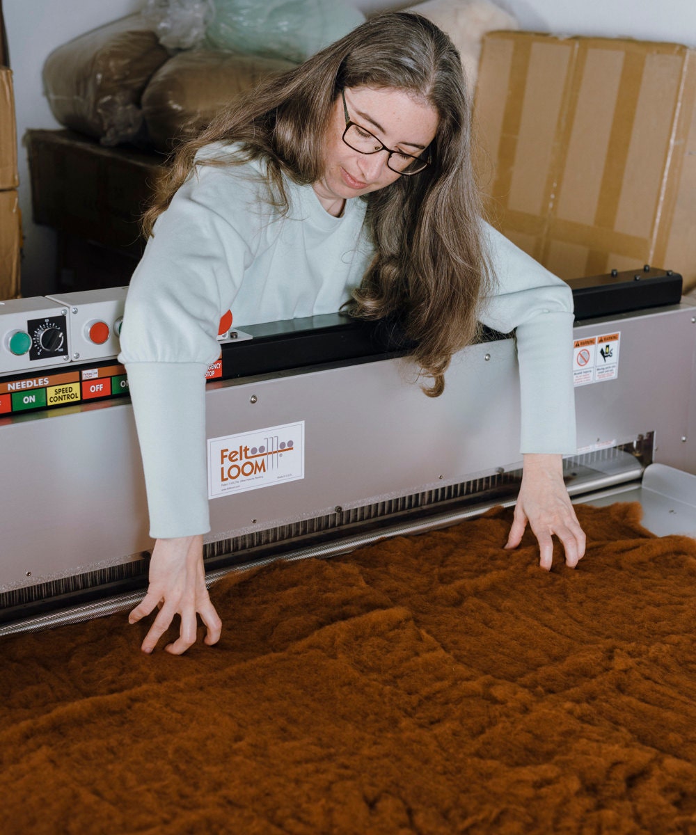 Elizabeth lays out wool on a felt loom.