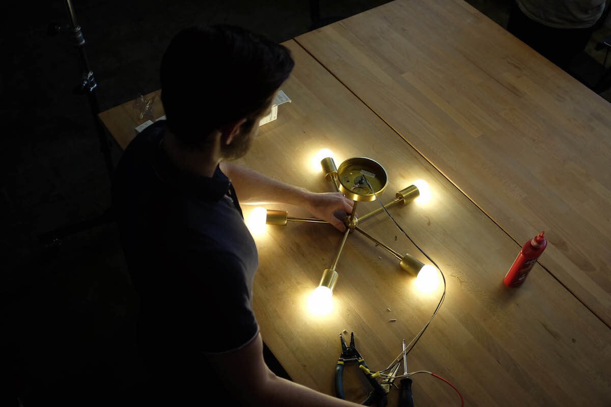 Kyle tests the wiring of a piece of lighting in his studio