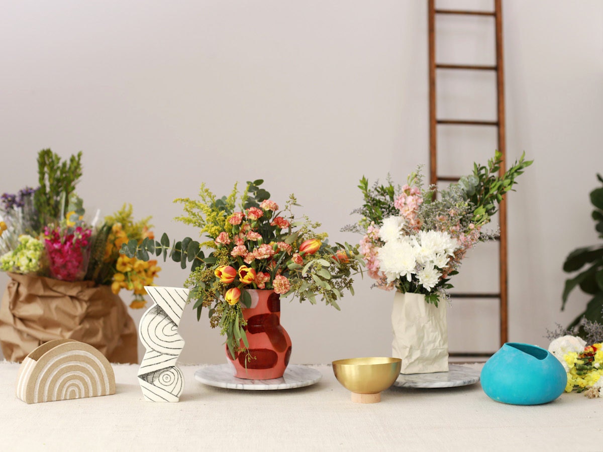 Floral arrangements in Etsy vases on display