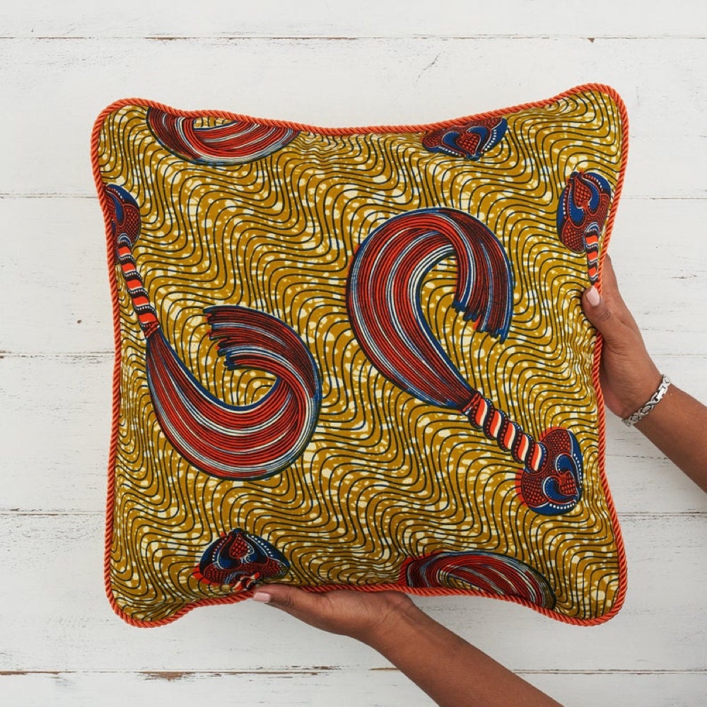 A gold and orange throw pillow cover from Bespoke Binny