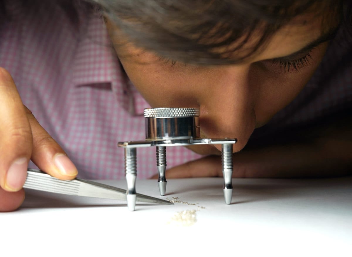 Abhishek examines stones under a magnifying glass