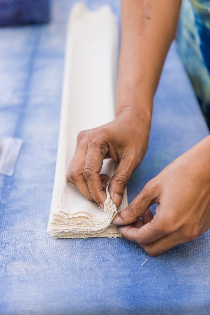 Adroit proprietor Rajni folds a long strip of fabric