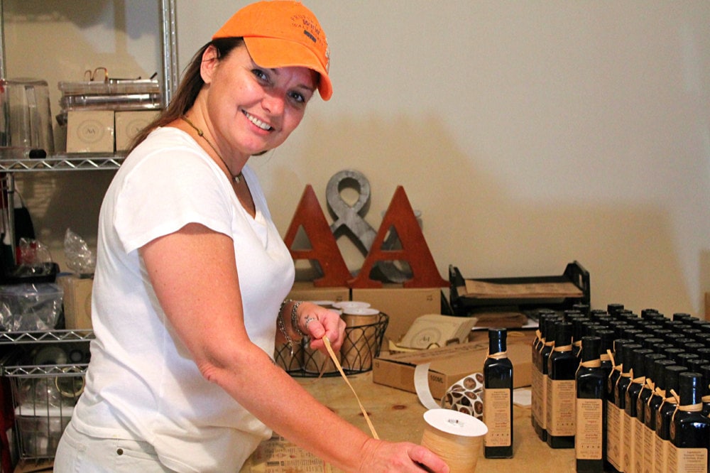 Adriana at work labeling her bottles of balsamic