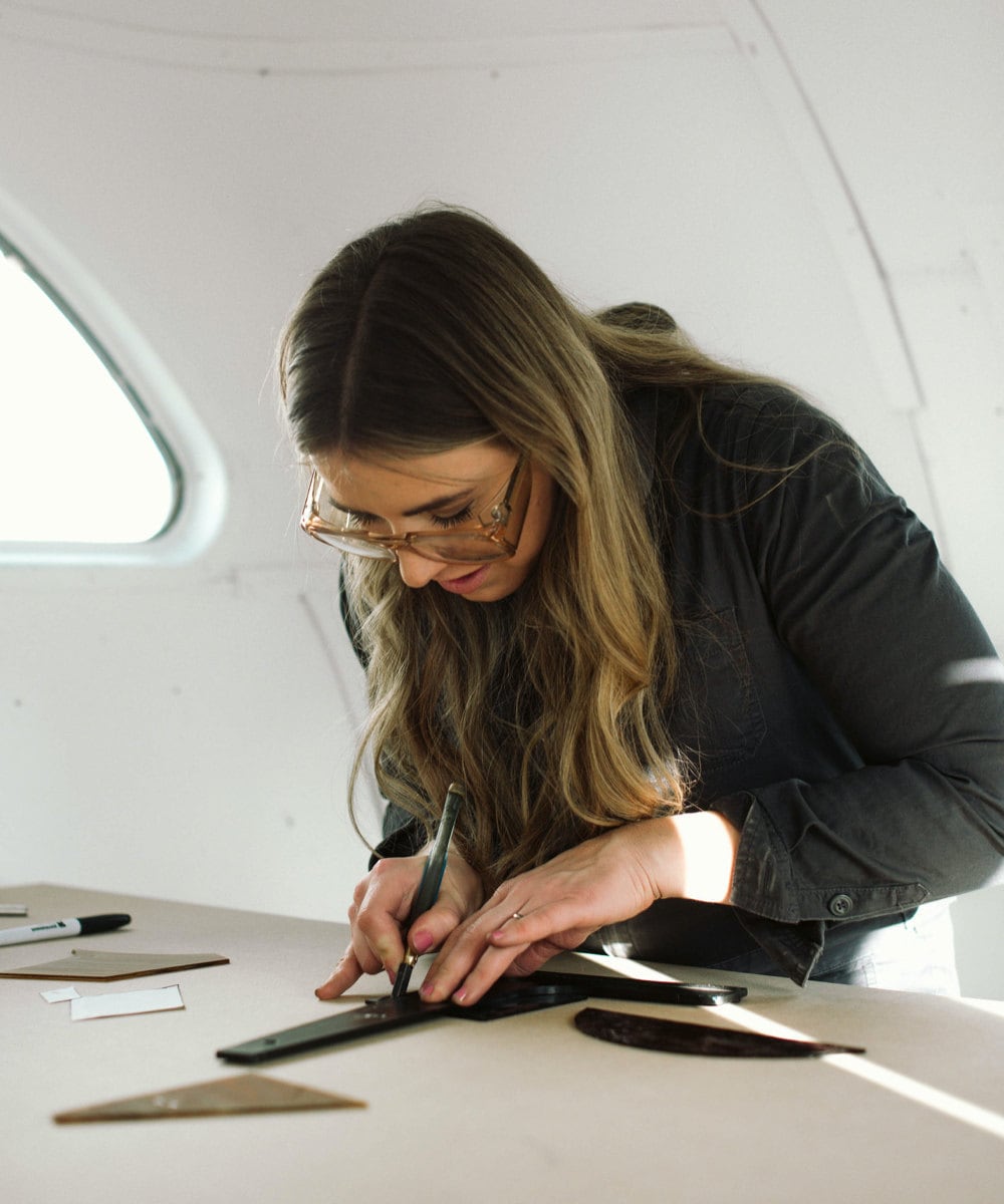 Lauren measures pieces of glass to make a precise cut.