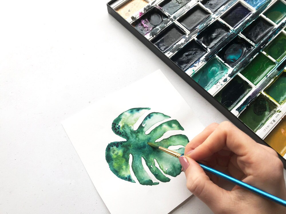 Mica paints a botanical watercolor.