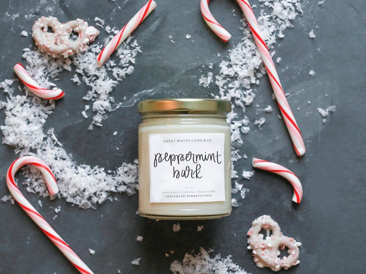 Peppermint bark candle styled against a backdrop of chopped candy canes