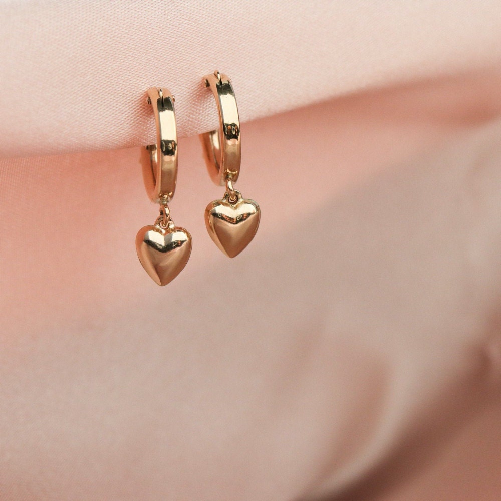 A set of tiny gold drop earrings shaped like hearts from EVREN.